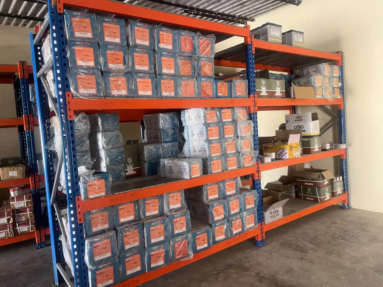 Racking of self drilling hex screw cartons at the Modern Fastening Solution warehouse, shelves hand-labelled 12 x 55 hex and 10 x 95 hex