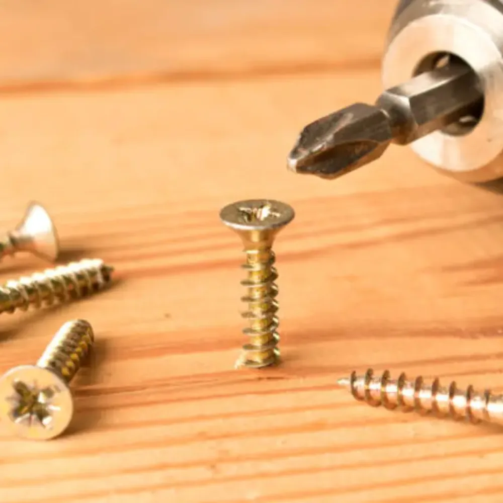 Chipboard screws being driven into timber and composite board in joinery work