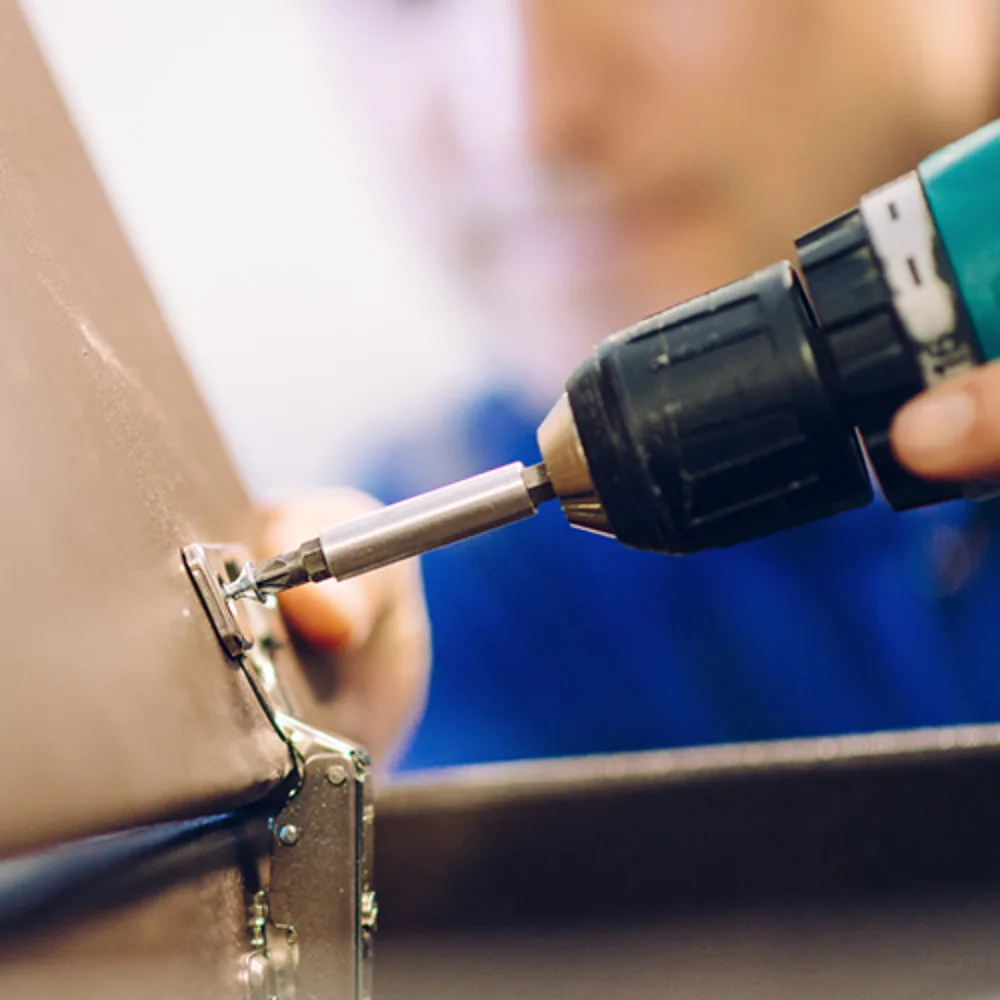 A power screwdriver fitted with a nut setter driving a fastener